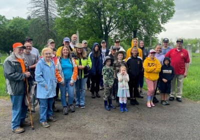 More than two dozens volunteers pause for a photo before spreading out across the 46-acre Greenwood Cemetery on Saturday morning to place flags on the graves of more than 930 veterans who are buried there.